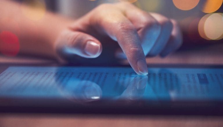 Woman reading online news on digital tablet